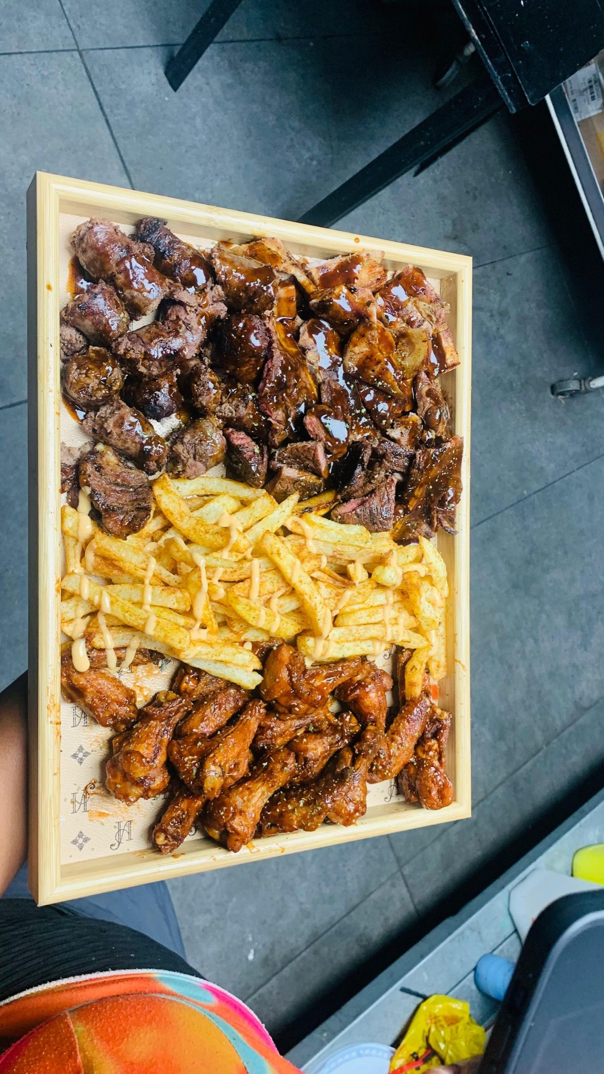 A Black Diamond braai board: cubes of grilled beef, chargrilled chicken wings and hot chips on a wooden tray.
