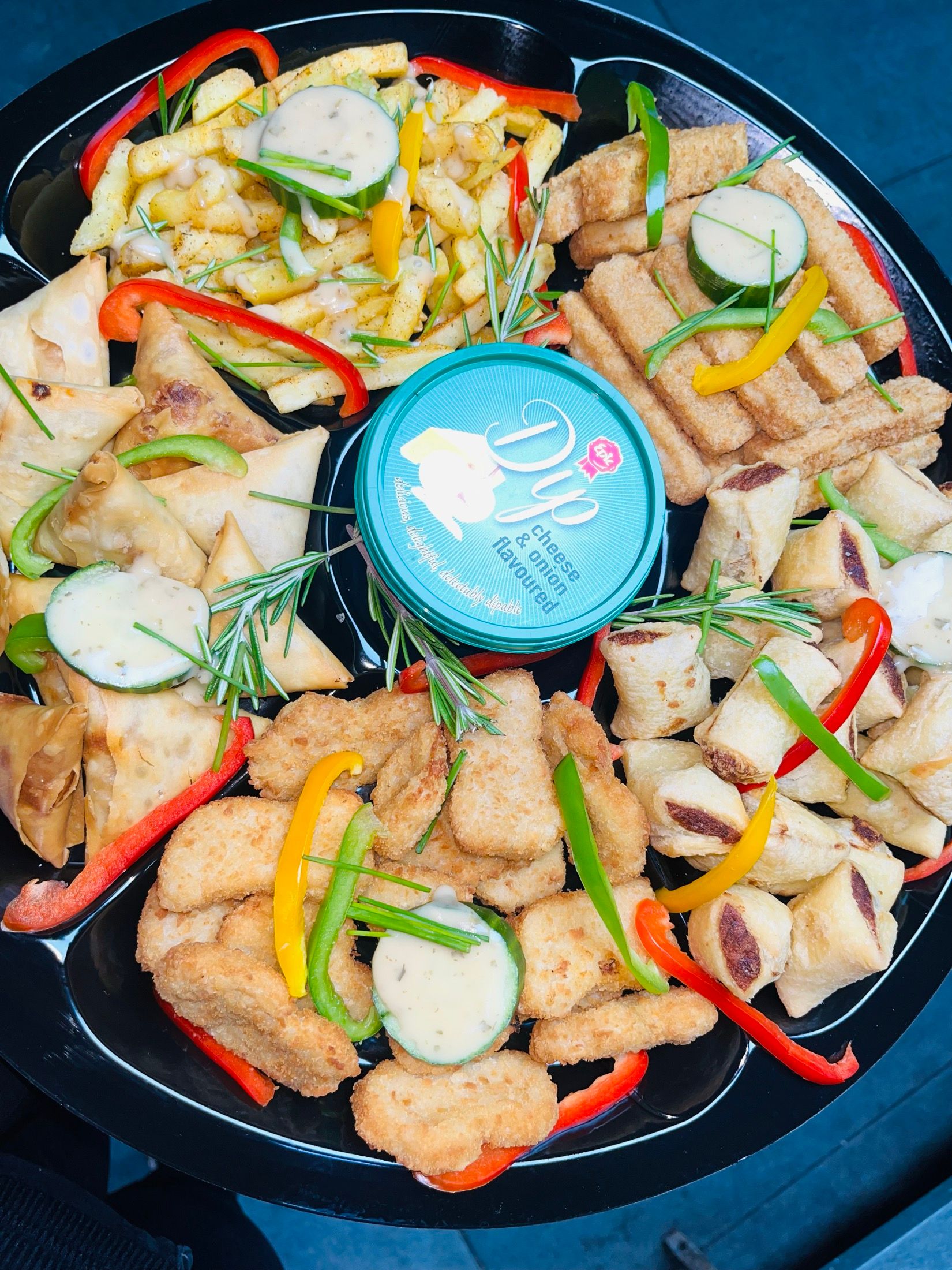 A Black Diamond catering platter: cheese sticks, crumbed nuggets, mini corn dogs and a tub of dip, with strips of red, green and yellow pepper.