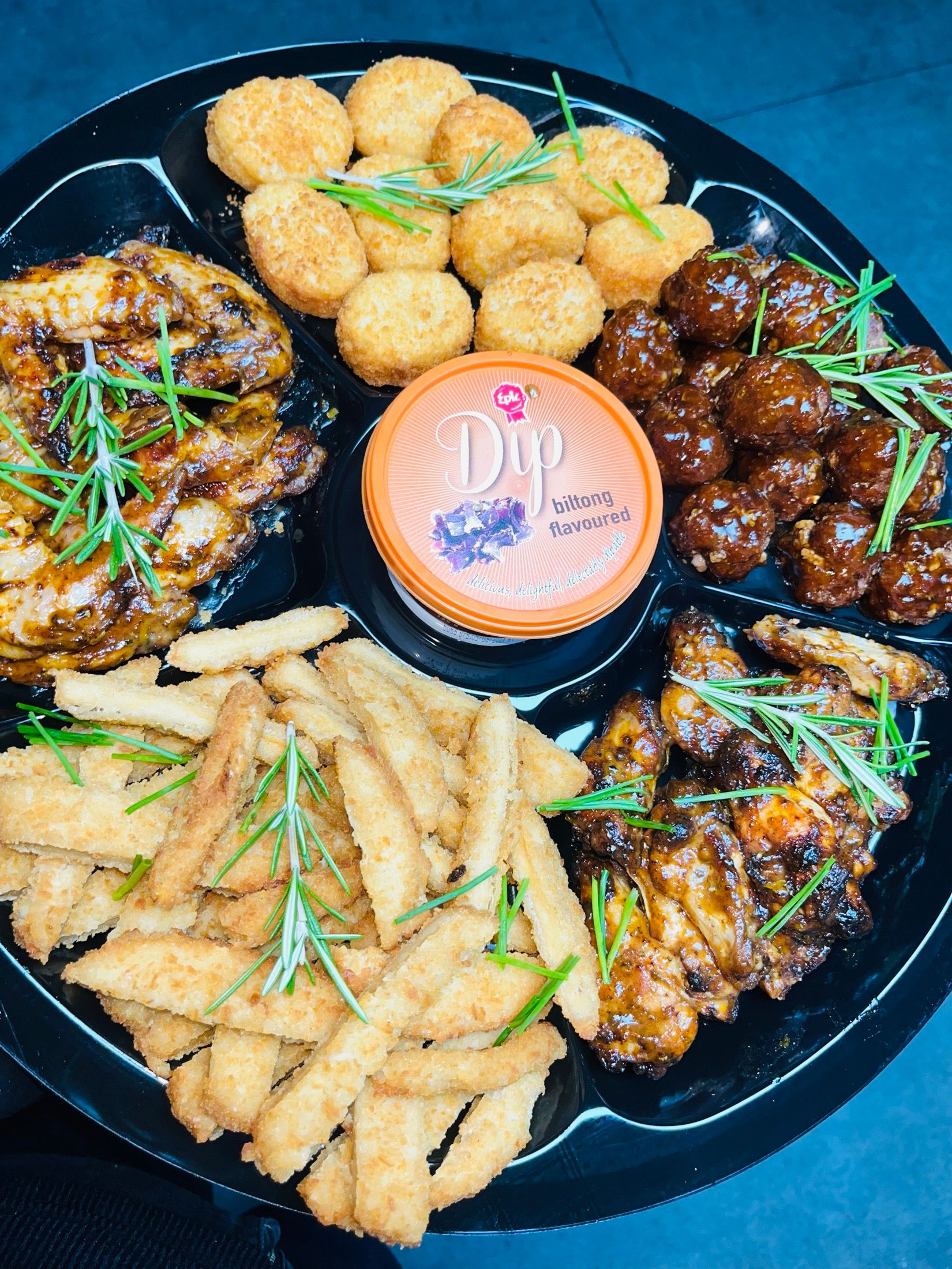 A Black Diamond catering platter: crumbed jalapeño poppers, sticky glazed meatballs, grilled chicken and cheese sticks around a tub of dip.
