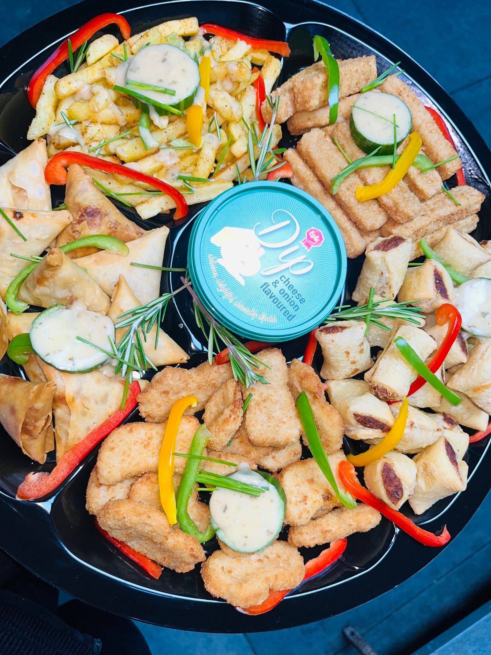 A Black Diamond catering platter: spring rolls, potato wedges, crumbed bites and frittata, dressed with pepper strips and rosemary.